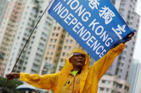 An anti-extradition bill protester holds a flag as he attends a march protest at Kwai Chung Sports Ground in Hong Kong