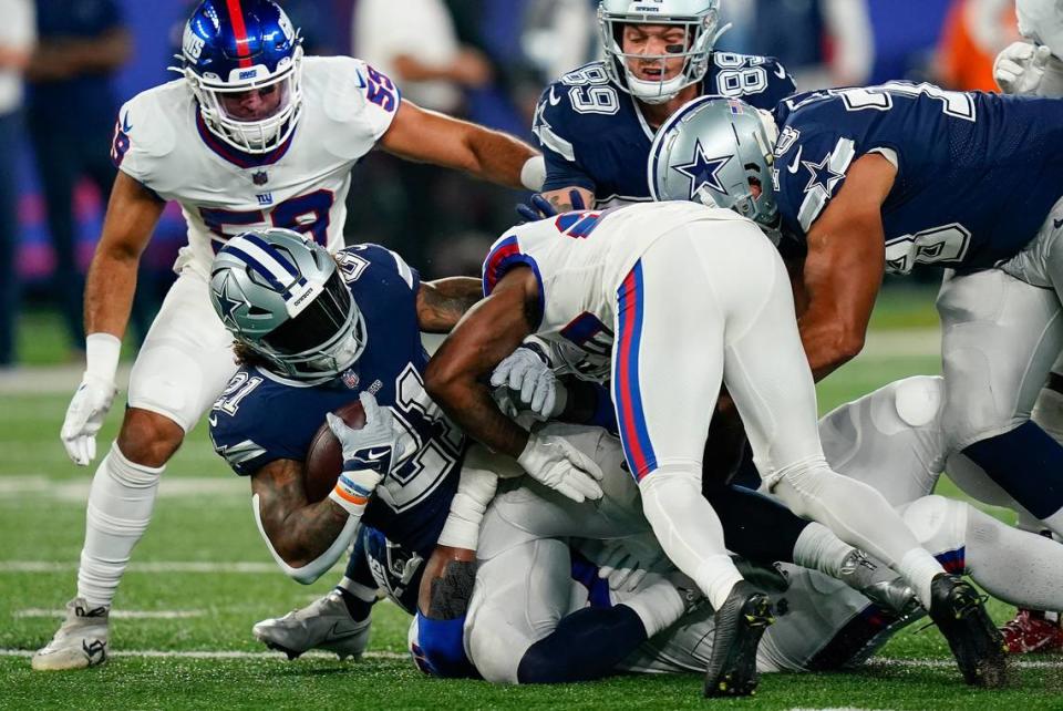 Dallas Cowboys running back Ezekiel Elliott (21) is tackled by the New York Giants during the first quarter of an NFL football game, Monday, Sept. 26, 2022, in East Rutherford, N.J. (AP Photo/Frank Franklin II)