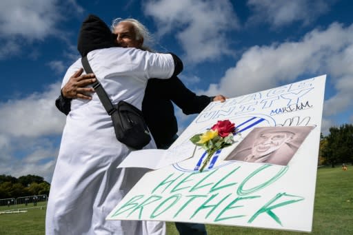 Mourners embrace after a two minute silence for the victims of the Christchurch attack, one of whom welcomed the man who was to open fire with the words "Hello brother" as he approached the Al Noor mosque