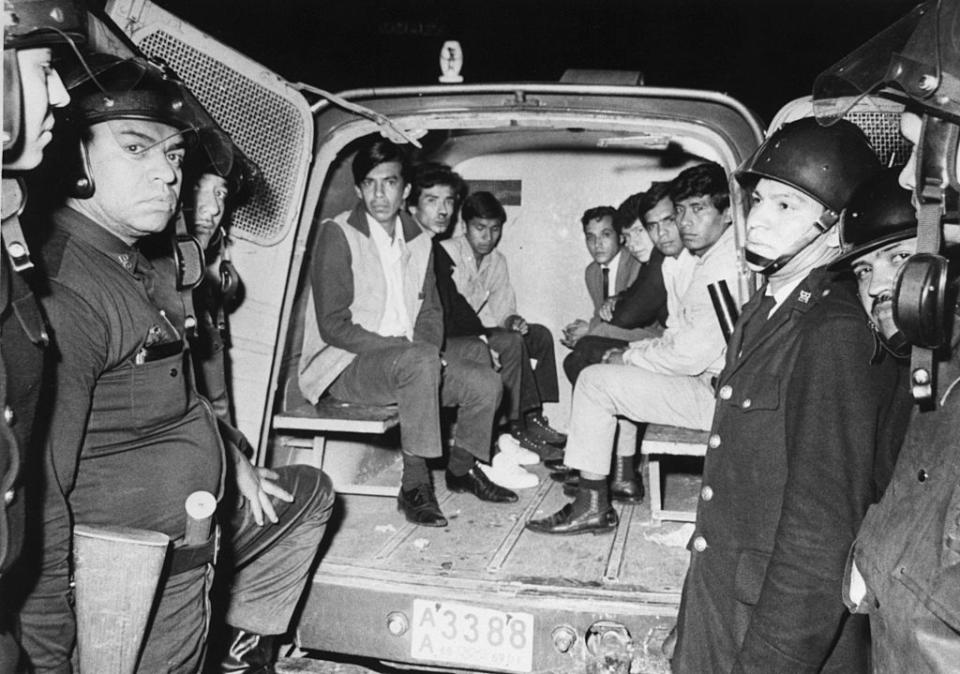 Siete jóvenes mexicanos están detenidos en una camioneta rodeada por seis policías en equipo antimotines el 3 de octubre de 1968 cerca de Tlatelolco, Ciudad de México (Bettmann Archive via Getty Images)