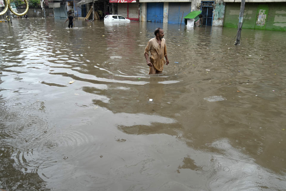 People wade through a flooded area caused by heavy monsoon rainfall in Lahore, Pakistan, Wednesday, July 5, 2023. Officials say heavy monsoon rains have lashed across Pakistan, killing a number of people. (AP Photo/K.M. Chaudary)