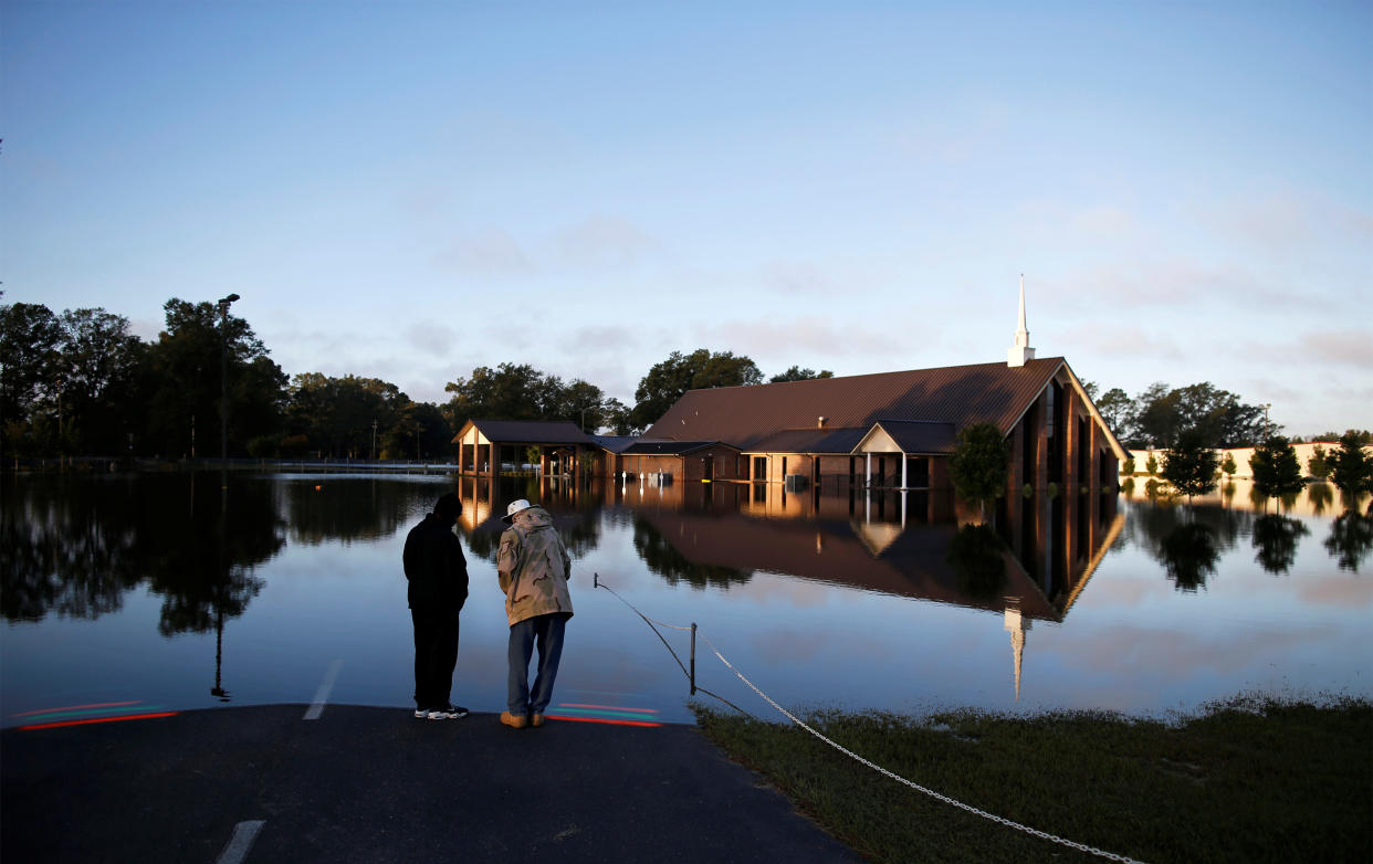 Steven Broadhurst (L) and Deacon Junius Shealy stand along the edge of the flood zone at St. Mark Church of Christ after the effects of Hurricane Matthew in Goldsboro, North Carolina, U.S., October 12, 2016. REUTERS/Randall Hill