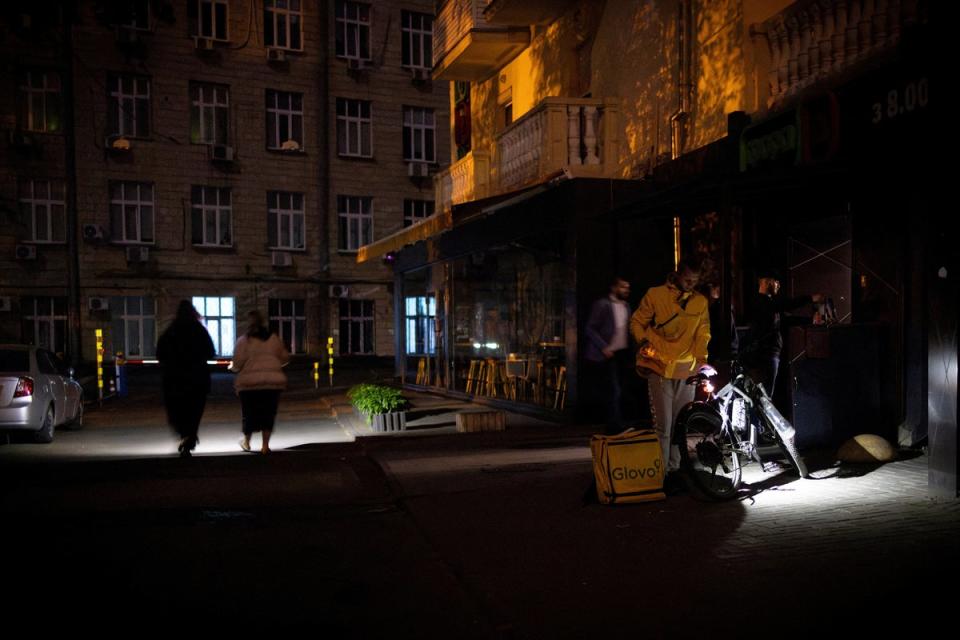 People use torches as they leave a supermarket during a partial electricity blackout in the Ukrainian capital Kyiv in May (Reuters)