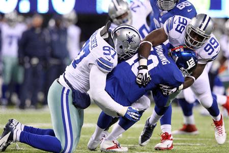 Nov 24, 2013; East Rutherford, NJ, USA; New York Giants quarterback Eli Manning (10) is sacked by Dallas Cowboys defensive tackle Jason Hatcher (97) and defensive end George Selvie (99) during the third quarter of a game at MetLife Stadium. Mandatory Credit: Brad Penner-USA TODAY Sports