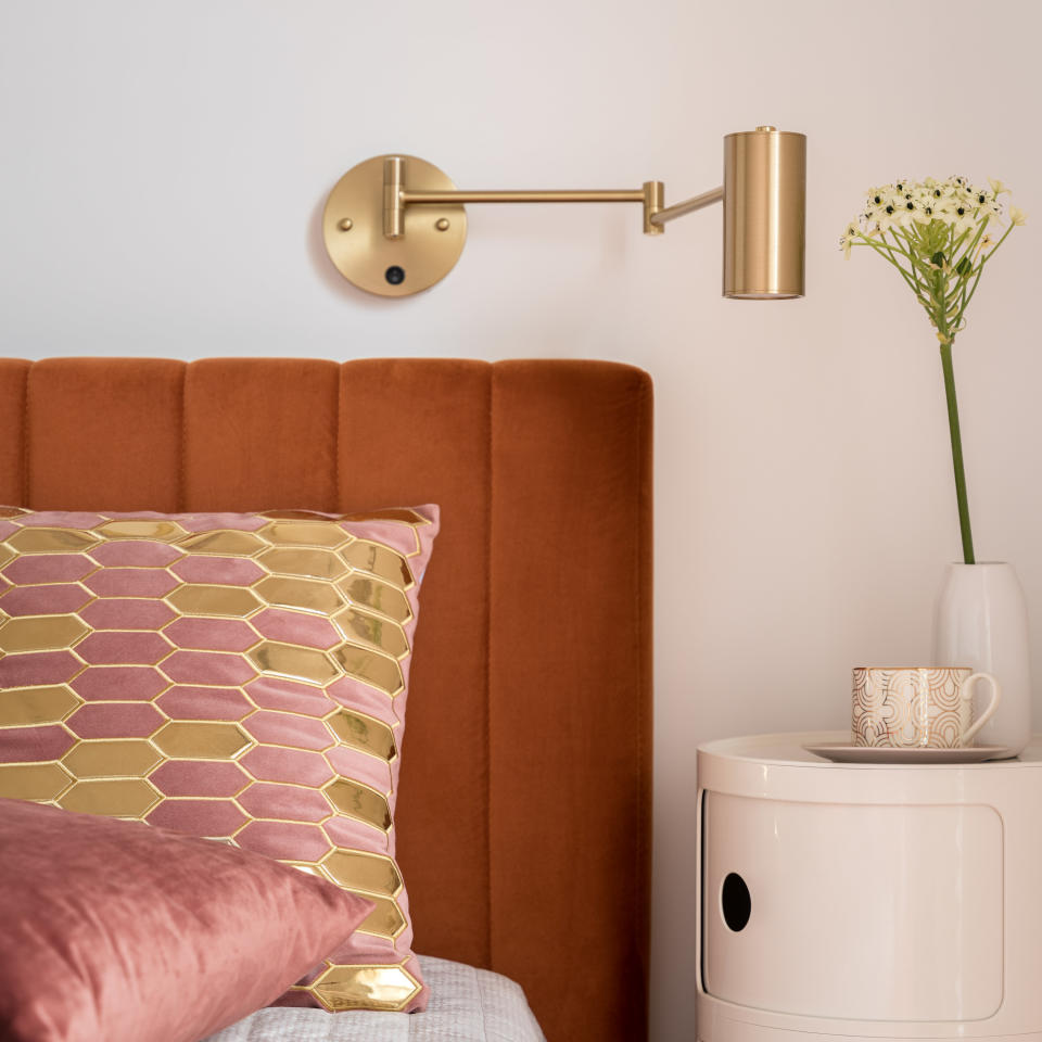 A bed with large pillows next to a bedside table