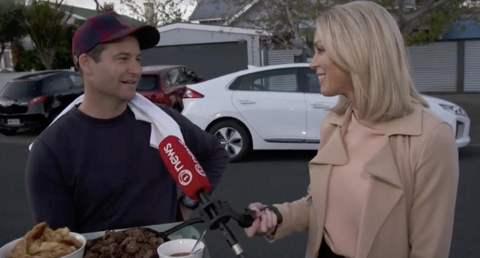 Clarke Gayford is pictured with a platter of food speaking to a news reporter outside his home in Auckland, New Zealand.