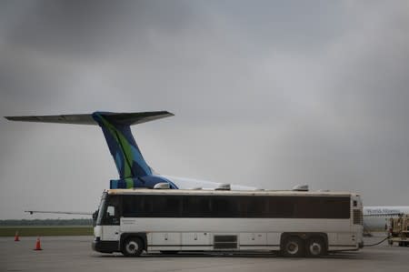 Transport buses used to carry migrants in U.S. Immigration and Customs Enforcement (ICE) custody are seen parked next to chartered planes before departure from Brownsville South Padre International Airport in Brownsville