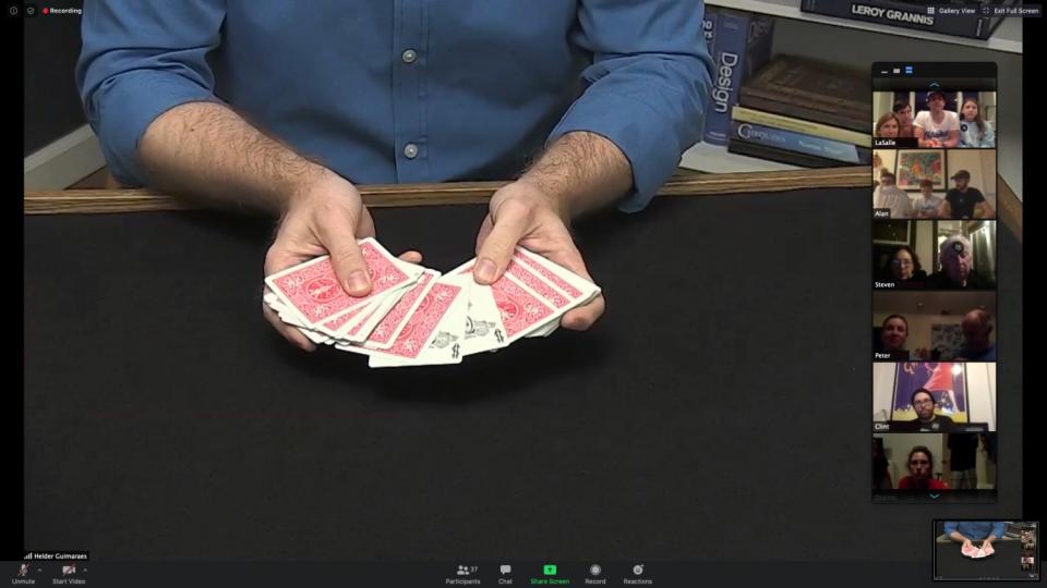 Magician Helder Guimarães holds out a deck of cards.