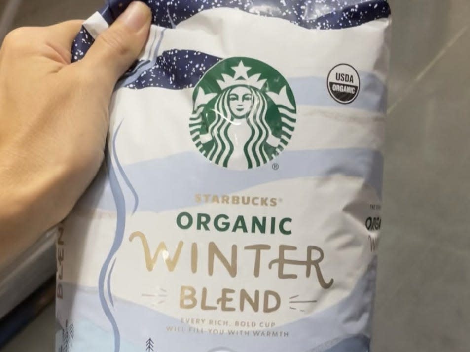 hand holding bag of starbucks winter blend coffee beans at costco