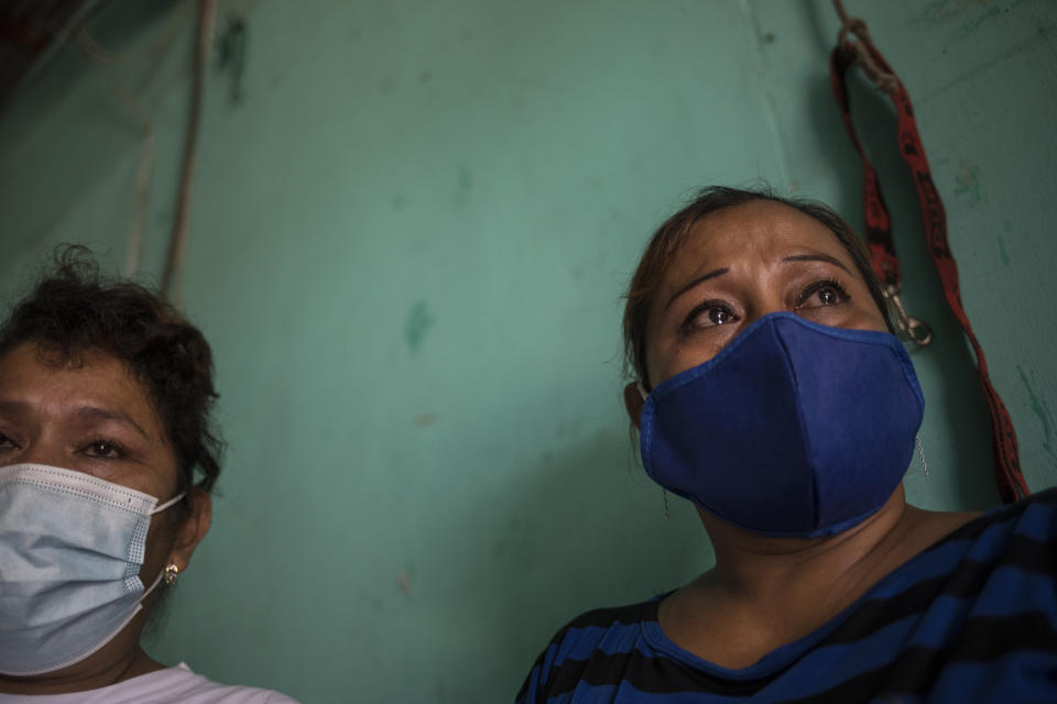 Marjorie Mayta, right, cries as she talks about her late brother Jose Mayta, who died from complications due to COVID-19, in her home on the outskirts of Iquitos, Peru, Saturday, March 20, 2021. Almost a year ago, Jose Mayta and dozens of other victims were clandestinely buried in a field larger than four soccer fields. Local authorities approved the burials but never told the families, who believed their loved ones were interred in the local San Juan cemetery. (AP Photo/Rodrigo Abd)