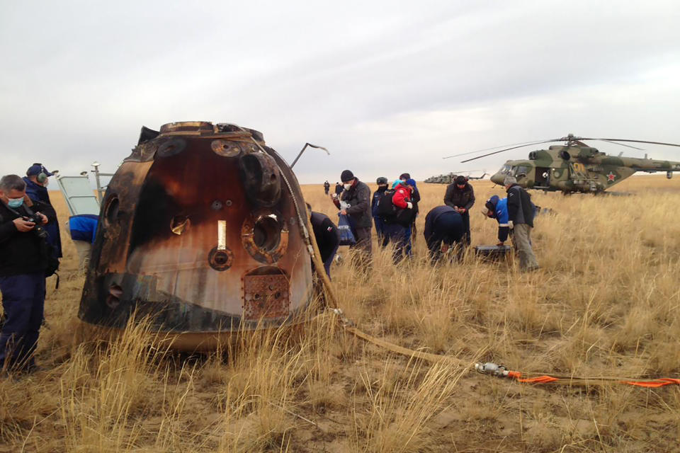 In this photo released by Roscosmos Space Agency, a Russian rescue team works near a Russian Soyuz MS-16 capsule landed near town of Dzhezkazgan, Kazakhstan, Thursday, Oct. 22, 2020. The Soyuz MS-16 capsule carrying NASA astronaut Chris Cassidy, and Roscosmos' Anatoly Ivanishin and Ivan Vagner landed on the steppes of Kazakhstan, southeast of the town of Dzhezkazgan, on Thursday. After a brief medical checkup, the three will be taken by helicopters to Dzhezkazgan from where they will depart home. (Roscosmos Space Agency via AP)