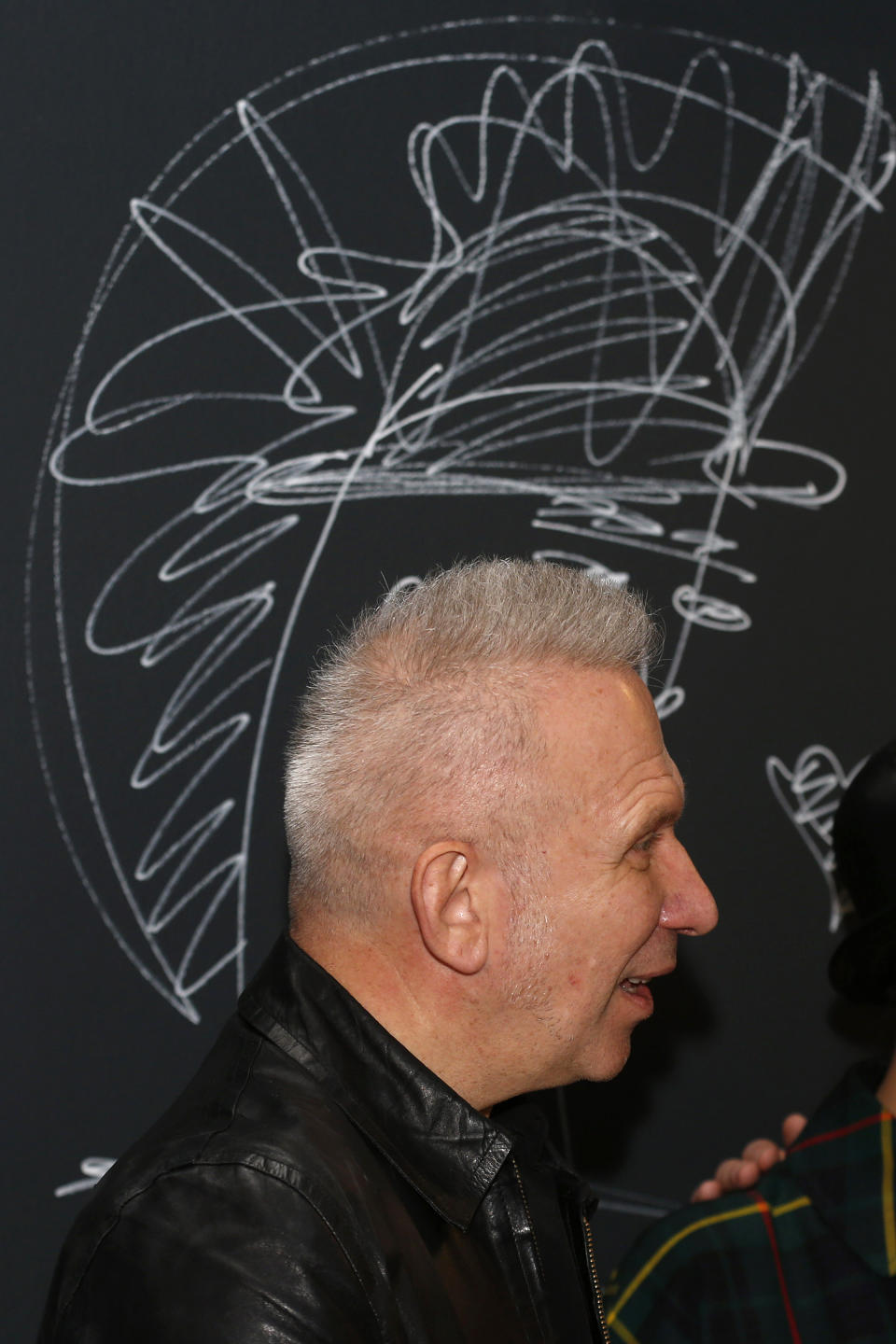 French couturier Jean Paul Gaultier looks on after he signed on the wall to launch of his exhibition 'The Fashion World of Jean Paul Gaultier : From the Sidewalk to the Catwalk' at the Barbican Art Gallery in London, Tuesday, April 8, 2014. (AP Photo/Sang Tan)