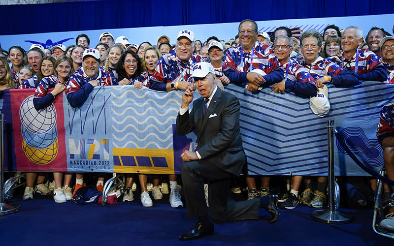 President Biden points to his hat as he poses for a photo