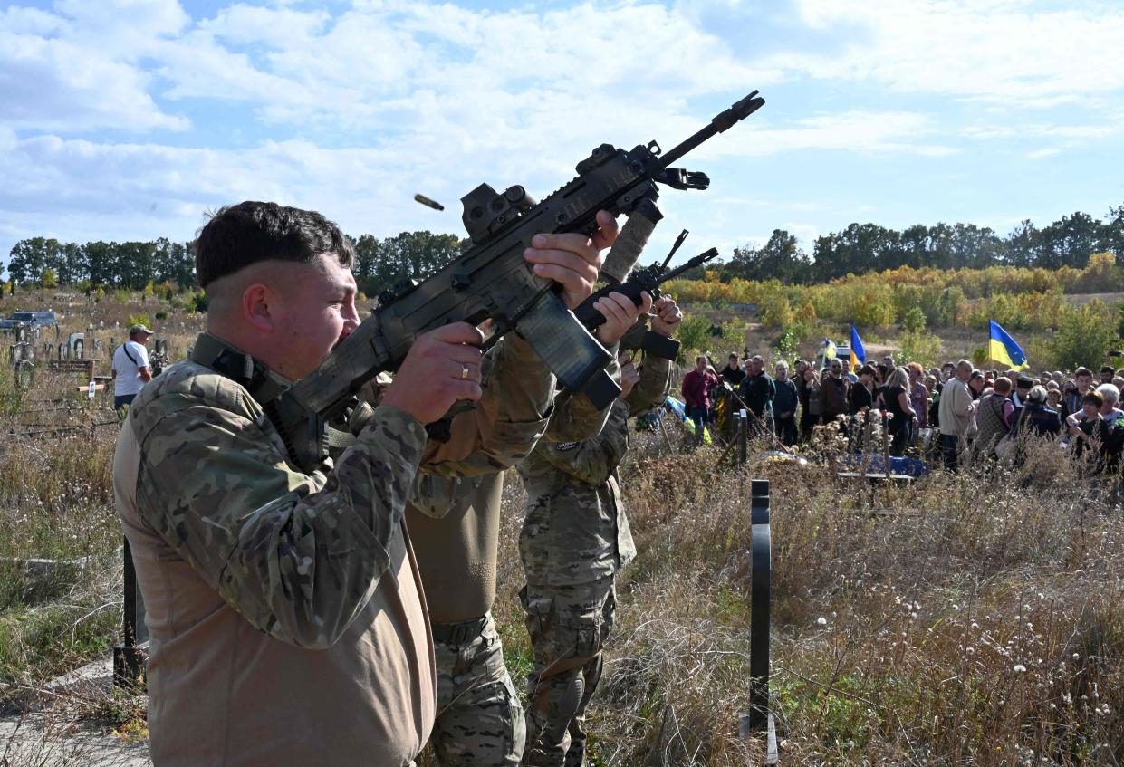 Ukrainian servicemen perform a rifle volley salute during the funeral ceremony of late Ukrainian volunteers Vadym Zabara, 51, and Sergiy Shalygin, 53, at a cemetery outskirts Kharkiv (AFP via Getty Images)