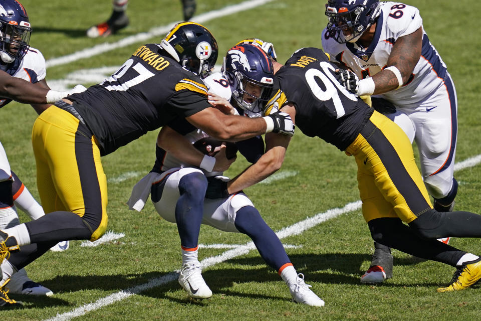 Denver Broncos quarterback Jeff Driskel (9) is sacked by Pittsburgh Steelers defensive tackle Cameron Heyward (97) and T.J. Watt (90) during the first half of an NFL football game, Sunday, Sept. 20, 2020, in Pittsburgh. (AP Photo/Keith Srakocic)