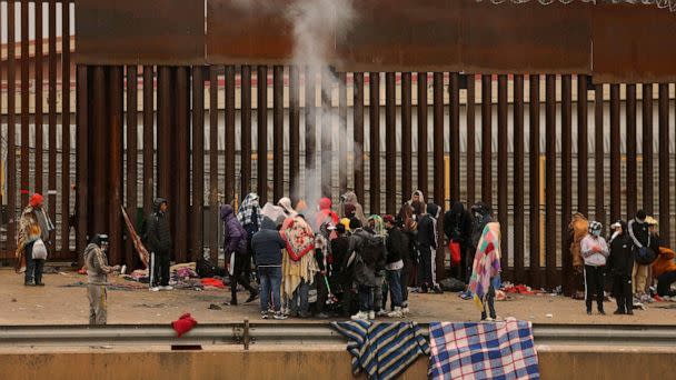 PHOTO: Migrants seeking asylum in the United States stand around a fire to keep warm after crossing the Rio Grande from Ciudad Juarez in Chihuahua, Mexico, Jan. 2, 2023. (Herika Martinez/AFP via Getty Images)