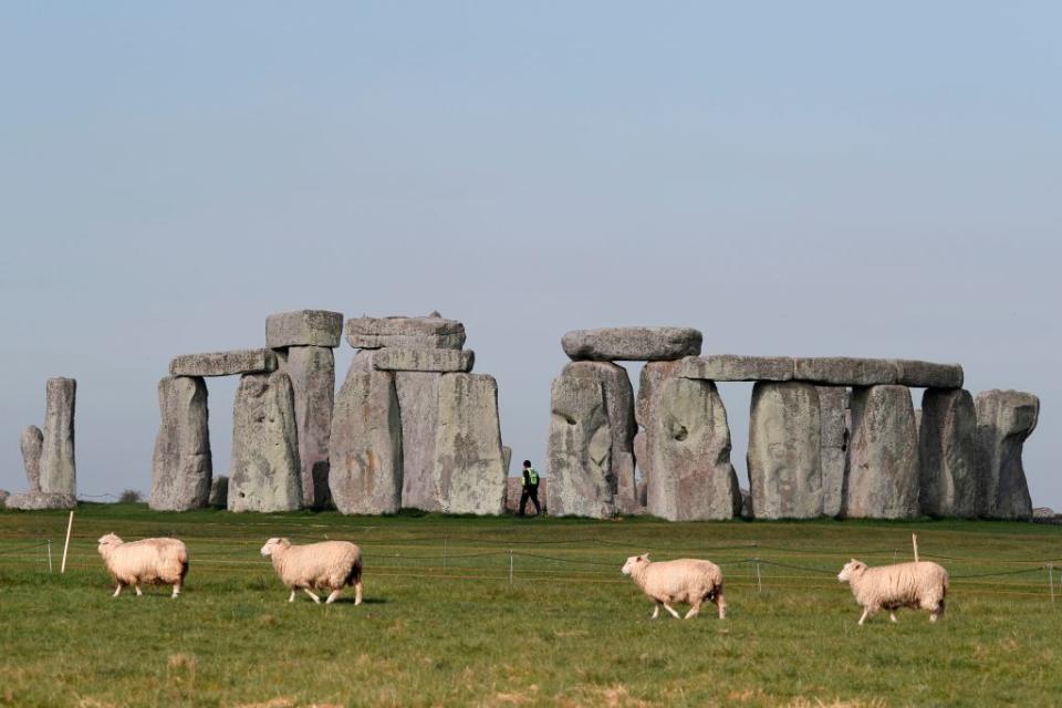 Sheep graze as security guards patrol the prehistoric monument at Stonehenge in southern England. Source: Getty