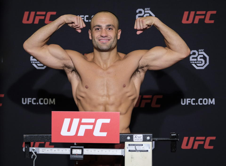 FILE - UFC lightweight fighter Eddie Alvarez flexes during a weigh-in in Calgary, Alberta, in this Friday, July 27, 2018, file photo. Demetrious Johnson and Eddie Alvarez won UFC championships before leaving their native U.S. to pursue another title overseas. Their home fans will get to see their next fights in Singapore thanks to One Championship's new series of fight cards on TNT. (Jeff McIntosh/The Canadian Press via AP, File)