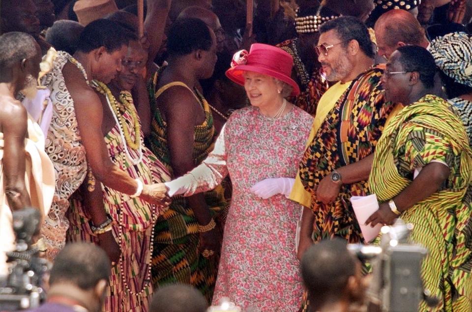 FILE - In this Monday, Nov. 8, 1999 file photo, Britain's Queen Elizabeth II, flanked to the right by Ghanaian President Jerry Rawlings, shakes hands with one of over a dozen Ghanaian tribal chiefs lined up to greet her, at an outdoor ceremony in Accra, Ghana. Ghana's former president Jerry Rawlings, who staged two coups and later led the West African country's transition to a stable democracy, has died aged 73, according to the state's Radio Ghana and the president Thursday, Nov. 12, 2020. (AP Photo/Brennan Linsley, File)