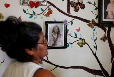 Ana Henriquez stands next to a photograph of her granddaughter Alison Valencia, who was detained along with her mother and then separated when they arrived in the U.S., in Armenia, El Salvador June 20, 2018. REUTERS/Jose Cabezas