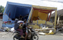 <p>A motorcycle passes buildings destroyed by Sunday’s earthquake in North Lombok, Indonesia, Friday, Aug. 10, 2018. (Photo: Firdia Lisnawati/AP) </p>