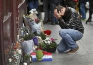 A man pays his respect outside the Le Carillon restaurant the morning after a series of deadly attacks in Paris , November 14, 2015. REUTERS/Christian Hartman