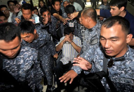 Former Maguindanao Governor Andal Ampatuan Sr (centre) is surrounded by police at a court in Manila in March. A man who testified in court on the Philippines' worst political massacre -- for which Ampatuan is on trial -- was found dead "probably chain-sawed to pieces" in a killing meant to silence other witnesses, an official said Friday