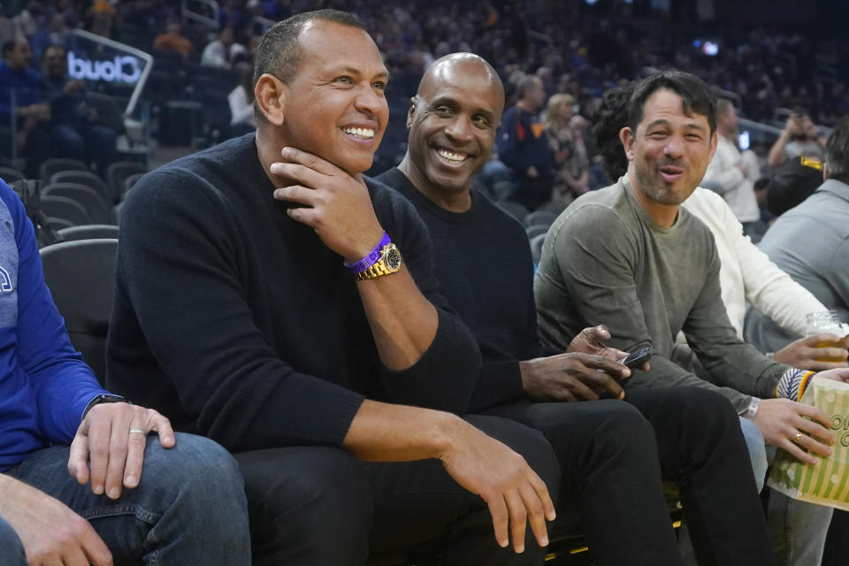 Minnesota Timberwolves co-owner Alex Rodriguez, left, talks with former baseball player Barry Bonds before an NBA basketball game between the Golden State Warriors and the Timberwolves in San Francisco, Sunday, Feb. 26, 2023. (AP Photo/Jeff Chiu)