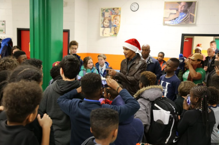 Barack Obama dons Santa hat to deliver Christmas presents to children