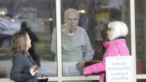 Kaye Knighton, 86, receives a visit from his daughter-law Darla Knighton, left, and Debbie Atkins, right, at the Creekside Senior Living Tuesday, March 24, 2020, in Bountiful, Utah. Window visits help seniors connect to families despite coronavirus restrictions. (AP Photo/Rick Bowmer)