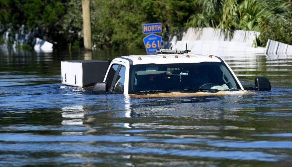 A truck sits on a section of road flooded by the Peace River in Arcadia on Sept. 30, 2022.