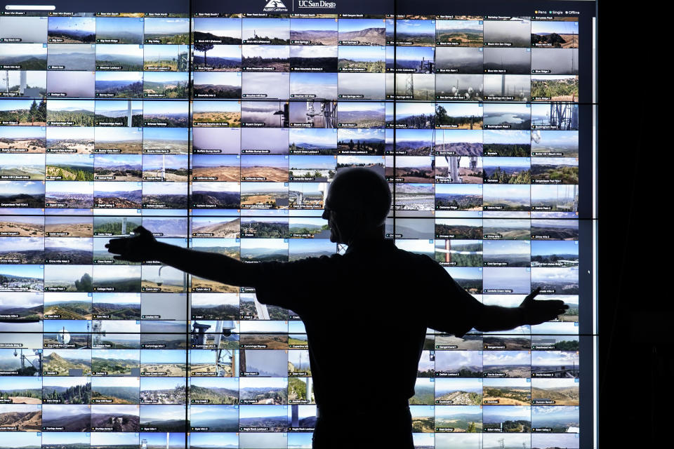 Falco Kuester, a researcher at ALERTCalifornia, a program run by the University of California San Diego, looks at live feeds from some of the program's cameras, Monday, Sept. 18, 2023, in San Diego. California's main firefighting agency, Cal Fire, in July started trying out an artificial intelligence system that looks for smoke from more than 1,000 mountaintop cameras feeds. (AP Photo/Gregory Bull)