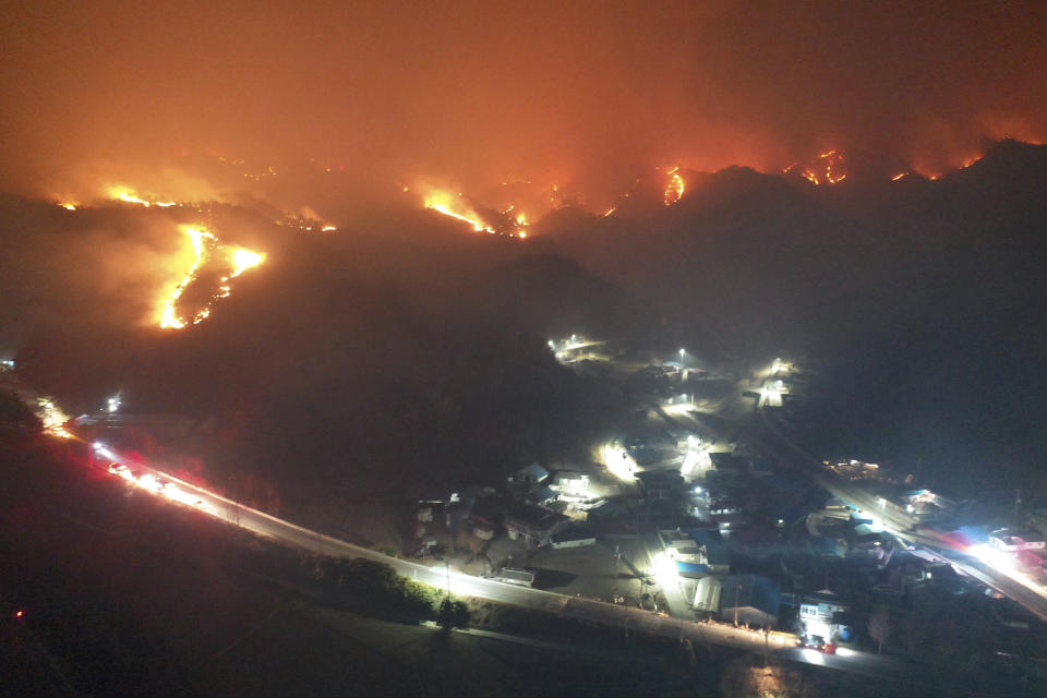 A wildfire burns on a mountain in Samcheok, South Korea, Friday, March 4, 2022. Thousands of South Koreans were forced to flee their homes Friday after a large wildfire ripped through an eastern coastal area and temporarily threatened a nuclear power station before being driven away by winds. (Kim Huyn-tae/Yonhap via AP)