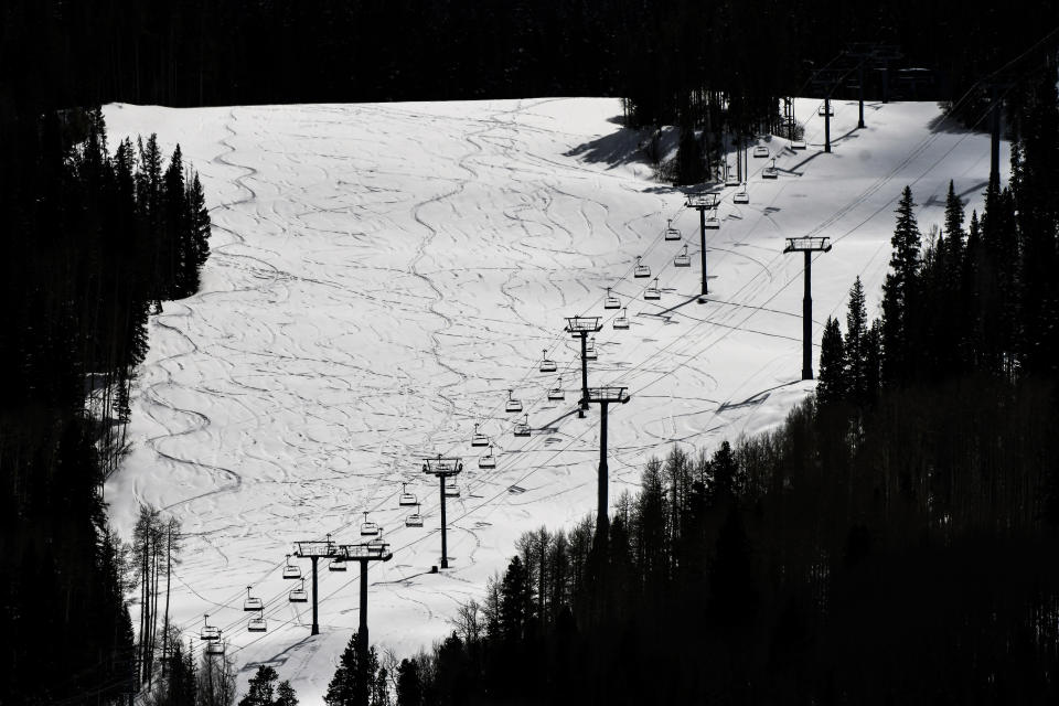 This Tuesday, March 24, 2020 photo shows ski lifts empty in Vail, Colo., after Vail Ski Resort closed for the season amid the COVID-19 pandemic. The closure has ended the normally busy spring ski season more than a month early. (AP Photo/Michael Ciaglo)