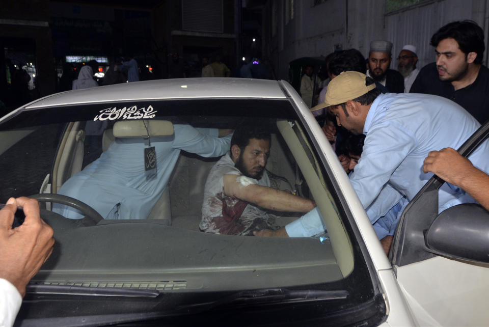 People transport an injured victim of a powerful bomb upon arrival at a hospital in Peshawar, Pakistan, Sunday, July 30, 2023. A bomb ripped through a rally by supporters of a hard-line cleric and political leader in the country's northwestern Bajur district that borders Afghanistan on Sunday, police and health officials said. (AP Photo/Muhammad Sajjad)