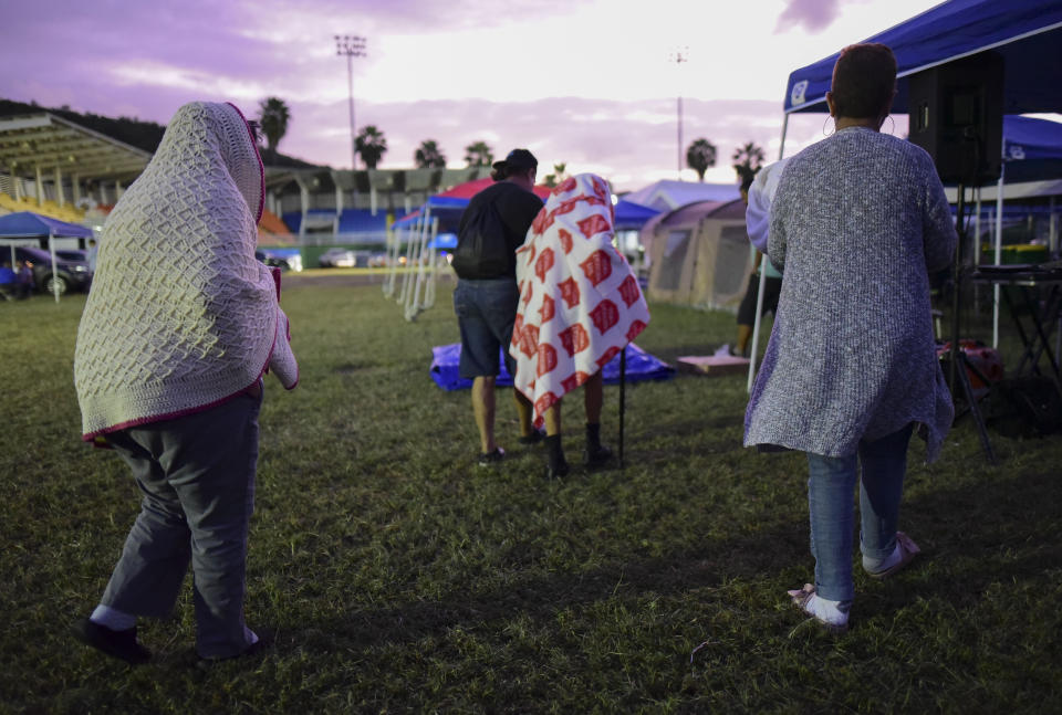 Varias personas se ponen de pie luego de pasar la noche en un estadio de béisbol tras un sismo de magnitud 6,4 en Guayanilla, Puerto Rico, el viernes 10 de enero de 2020. (AP Foto/Carlos Giusti)