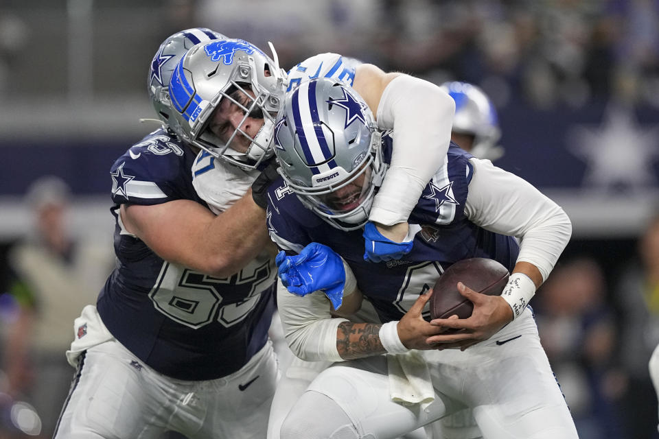 Dallas Cowboys quarterback Dak Prescott, right, is sacked by Detroit Lions defensive end Aidan Hutchinson, center, as Cowboys center Tyler Biadasz (63) tries to block during the first half of an NFL football game, Saturday, Dec. 30, 2023, in Arlington, Texas. (AP Photo/Sam Hodde)