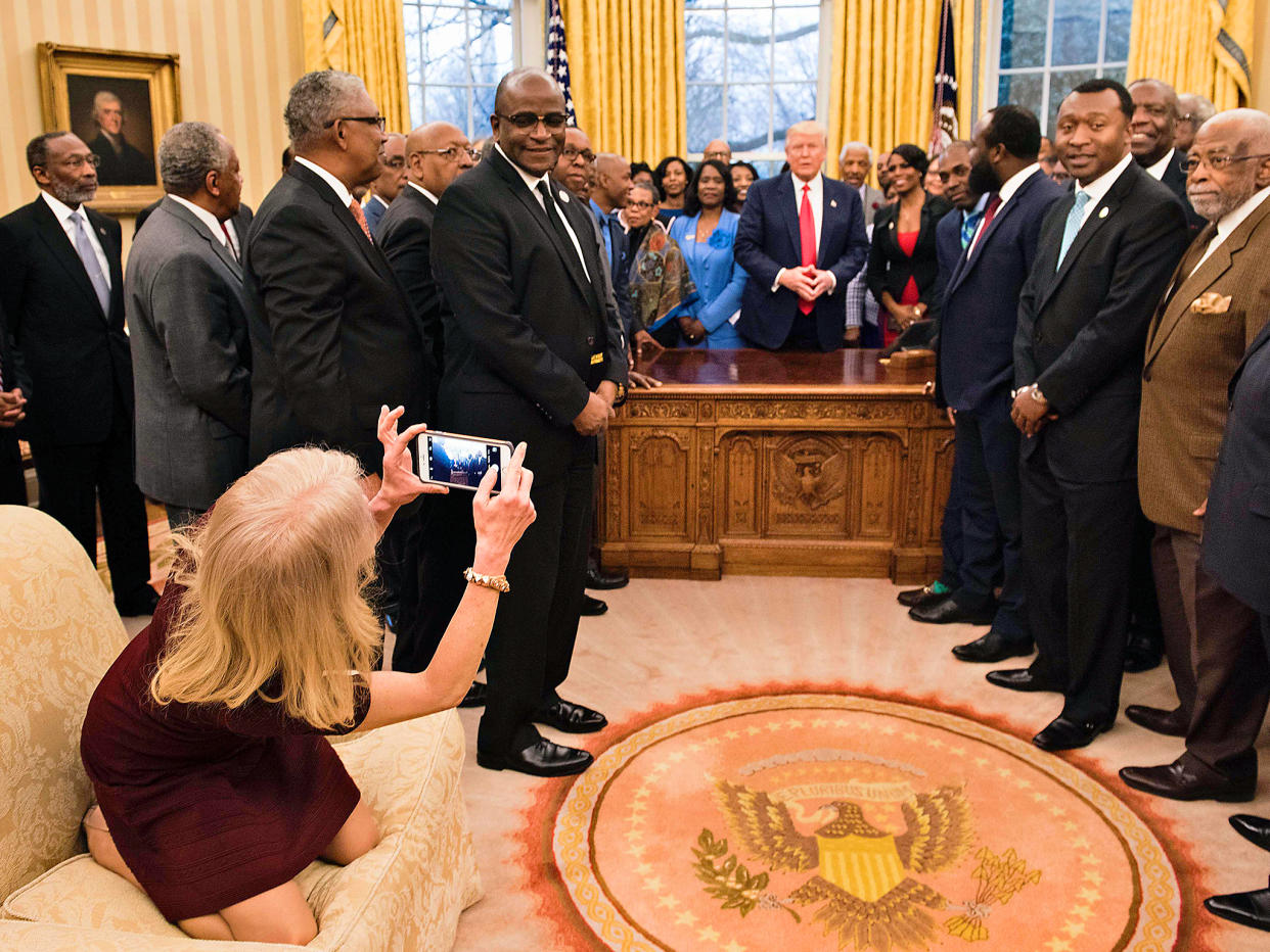 Counselor to the President Kellyanne Conway takes a photo as US President Donald Trump and leaders of historically black universities and colleges talk before a group photo in the Oval Office of the White House: Getty Images