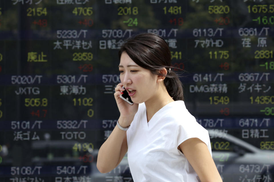 A woman walks by an electronic stock board of a securities firm in Tokyo, Tuesday, Sept. 24, 2019. Shares have edged higher in Asia as U.S. Treasury Secretary Steven Mnuchin confirmed that China-U.S. trade talks were due to resume in two weeks’ time. The Shanghai Composite index rose 0.8% and shares also rose in Tokyo and Hong Kong. (AP Photo/Koji Sasahara)