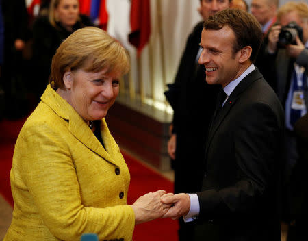 German chancellor Angela Merkel says farewell to French President Emmanuel Macron at the end of the first day of the European Union leaders summit in Brussels, Belgium December 15, 2017. REUTERS/Phil Noble