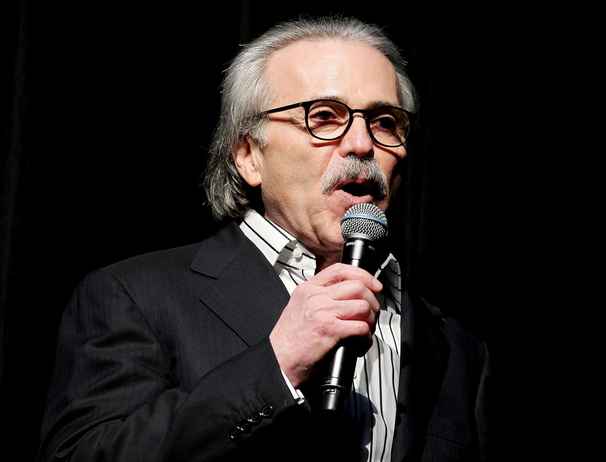 David Pecker, former CEO of American Media, holds a microphone.