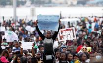 A demonstrator holds a sign during protest over alleged police brutality in Lagos