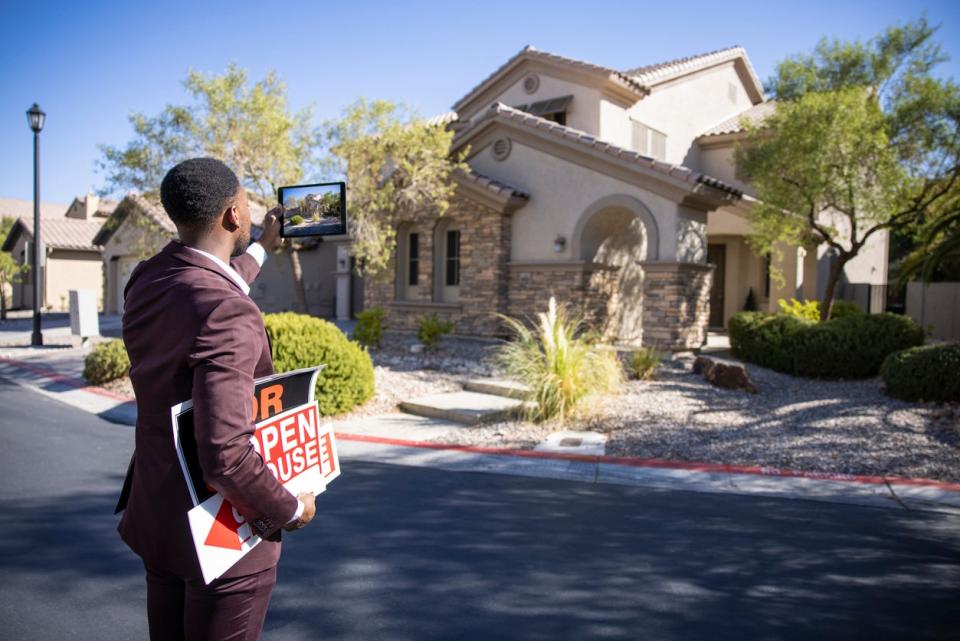 A male real estate agent holding 