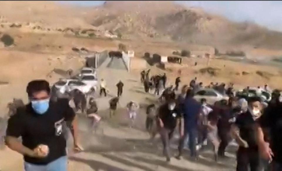 This image grab from a video posted on October 27, 2022, shows Iranian security forces clashing with crowds gathering near the grave of 16-year-old Nika Shahkarami, outside the western city of Khorramabad. (UGC/AFP via Getty Images)