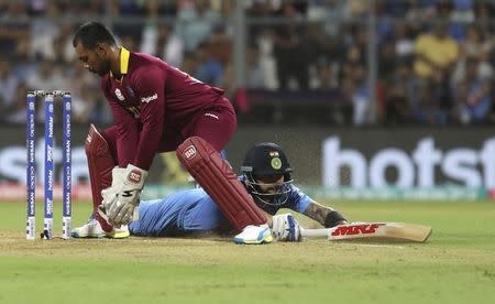 Cricket - West Indies v India - World Twenty20 cricket tournament semi-final - Mumbai, India - 31/03/2016. India's Virat Kohli (R) dives successfully to make his crease past West Indies wicketkeeper Denesh Ramdin. REUTERS/Shailesh Andrade -