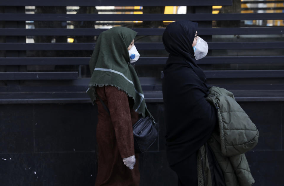 People walk as they wear masks in downtown Tehran, Iran, Thursday, Feb. 27, 2020. Amid fear and uncertainty caused by the spread of a new virus, Iranians are taking extra caution to avoid getting infected, as authorities canceled Friday prayers in Tehran, Qom and other cities. (AP Photo/Vahid Salemi)