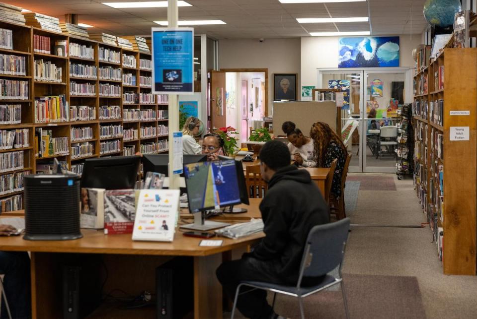 Residents of Bastrop County work at the Smithville Public Library in Smithville, Texas on Mar. 11, 2024. People work on computers, make phone calls and talk with each other in the main seating area of the library.