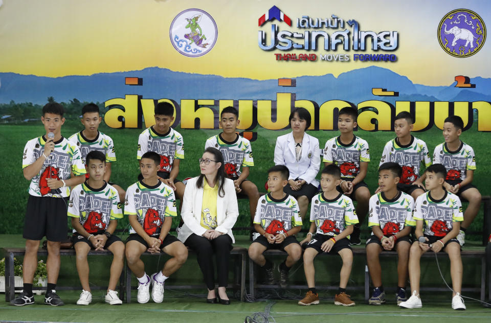 FILE - In this file photo dated Wednesday, July 18, 2018, Coach" Ake" Ekkapol Janthawong, left, speaks on behalf of the 12 boys and himself about their rescue from a flooded cave during a press conference discussing their ordeal in Chiang Rai, northern Thailand. The British divers who helped rescue young soccer players trapped in a flooded cave in Thailand are among those being recognized in Britain’s New Year’s Honors List, according to the list of recipients released Friday Dec. 28, 2018. (AP Photo/Vincent Thian, FILE)