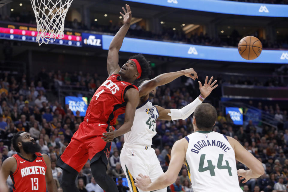Houston Rockets' Danuel House Jr. (4) and Utah Jazz's Donovan Mitchell (45) compete for a rebound during the first half of the team's NBA basketball game Saturday, Feb. 22, 2020, in Salt Lake City. (AP Photo/Kim Raff)