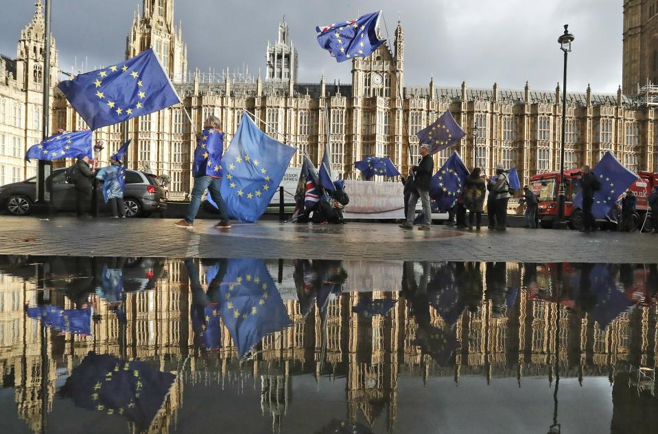 FILE - Protestors are reflected in a large puddle as they wave European flags to demonstrate against Brexit in front of the Parliament in London, Dec. 3, 2018. The U.K. election in December 2019 was basically about one issue: Brexit. General elections in the U.K. are typically held in the spring or early summer. But in the fall of 2019, the recently-appointed Prime Minister Boris Johnson gambled on holding one on December 12, when most people just want to get ready for Christmas and would rather think of anything but politics. (AP Photo/Frank Augstein, File)